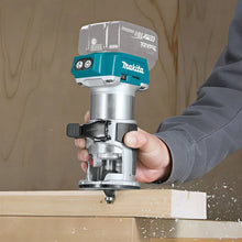 Makita DRT52 handheld router in use on woodwork in natural setting
