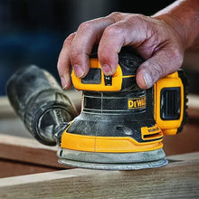 DEWALT DCW210 sander in use on wood surface, cordless yellow and black