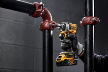 DEWALT DCF922 in-use lifestyle shot with LED light, working on pipes, yellow/black