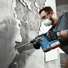 Bosch GBH 185-LI lifestyle shot of man using cordless hammer drill on wall