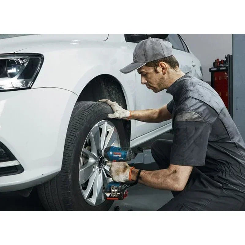 Bosch GDS 18V-400 impact wrench lifestyle shot with mechanic on car tire