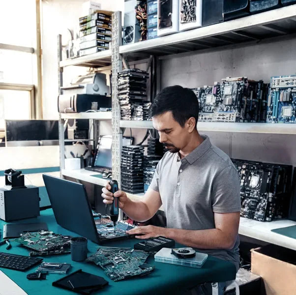 Bosch GO 2 lifestyle shot, man using cordless screwdriver at laptop workspace