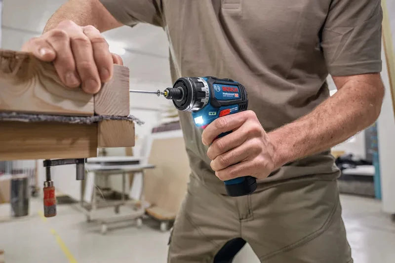 Bosch cordless drill lifestyle on wooden surface, blue and black grip