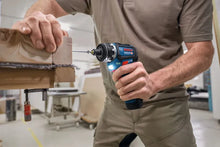 Bosch cordless drill lifestyle on wooden surface, blue and black grip