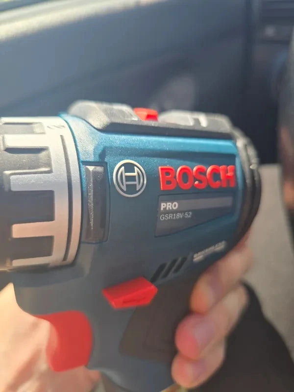 Bosch GSR18V-52 cordless drill held in hand, compact design, blue-black-red