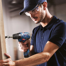Bosch GSR 120-LI detail of a man using the cordless drill on wood