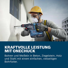 Bosch GBH 18V-22 X lifestyle shot, man drilling wall with blue cordless rotary hammer