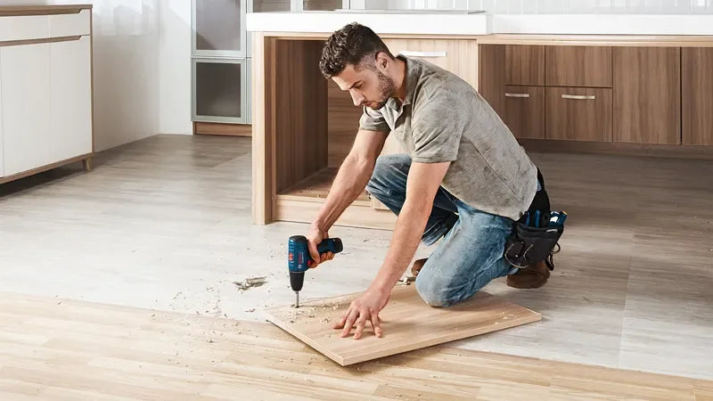 Bosch GSR 120-LI lifestyle shot, man using the cordless drill on wood