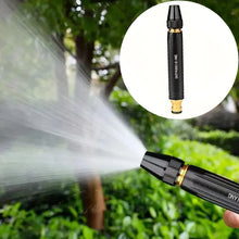 Spray nozzle in use with water stream, black and gold garden setting