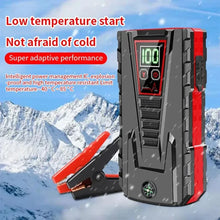 Car jump starter in black and red with digital display, front view.